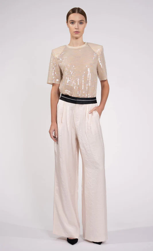 Gracie Top by Nonchalant | The Gracie Sequin Top is designed with shoulder pads and sequins for an eye-catching, glamorous look. This stylish t-shirt is available in a delicate blush hue that will glisten in the light. With expert craftsmanship and high-quality materials, the Gracie Top will be sure to shine. | Coretrade Located in Boca Raton, FL